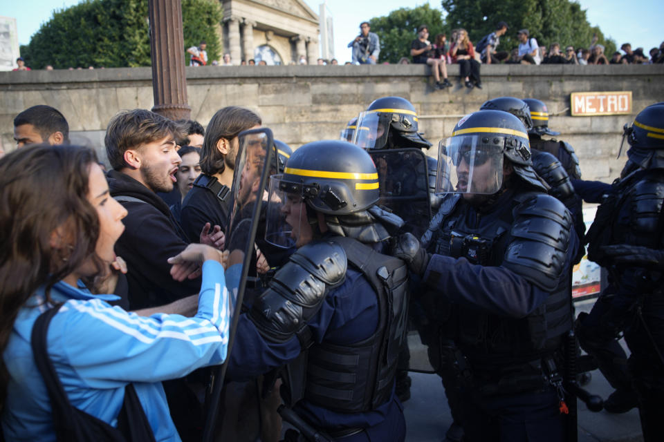 Police officers face protesters on Concorde square during a protest in Paris, France, Friday, June 30, 2023. French President Emmanuel Macron urged parents Friday to keep teenagers at home and proposed restrictions on social media to quell rioting spreading across France over the fatal police shooting of a 17-year-old driver. (AP Photo/Lewis Joly)