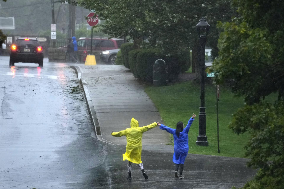 Two people dance in the rain during storm Lee, Saturday, Sept. 16, 2023, in Bar Harbor, Maine. Severe conditions were predicted across parts of Massachusetts and Maine, and hurricane conditions could hit the Canadian provinces of New Brunswick and Nova Scotia, where the storm, Lee, downgraded early Saturday from hurricane to post-tropical cyclone, was expected to make landfall later in the day. (AP Photo/Robert F. Bukaty)