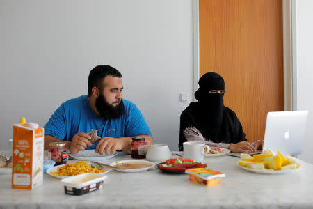Meryem, 20, a wearer of the niqab and a member of the group Kvinder I Dialog (Women In Dialogue), sits with her husband Ali, 23, as she updates her blog Niqabi Nuancer over a vegan breakfast in Aarhus, Denmark, July 28, 2018. REUTERS/Andrew Kelly