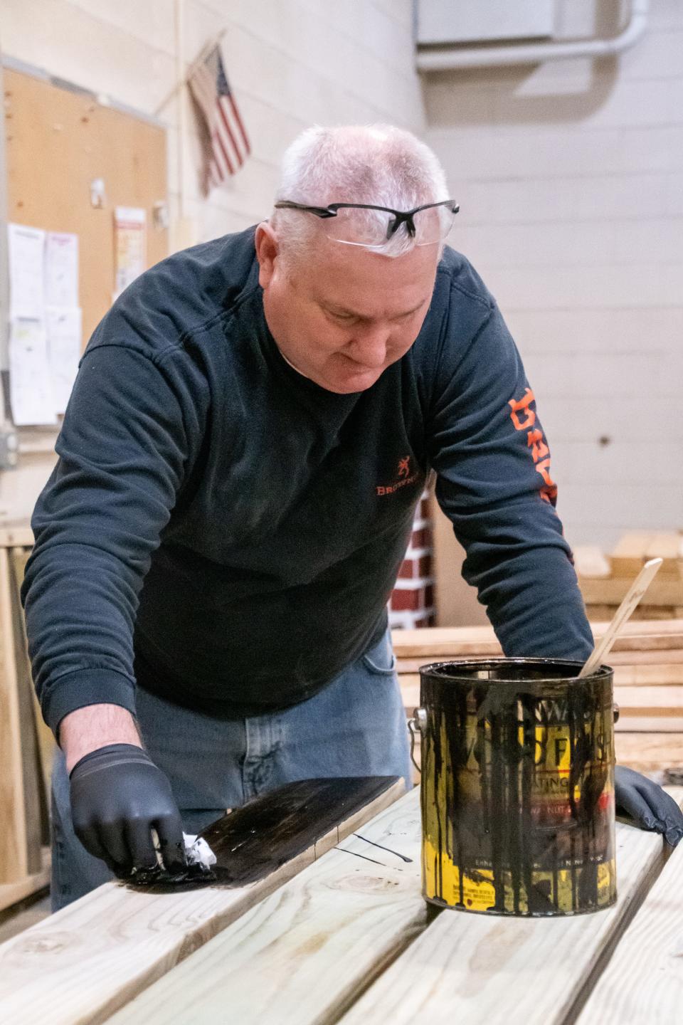 Bob Kruse stains a picnic table at Guernsey Industries. Kruse has been utilizing the organization's services for more than 30 years and has been hired on as a staff member.