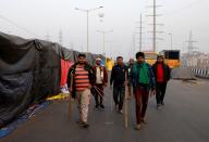 Farmers holding sticks patrol at the site of a protest against farm laws at Ghaziabad