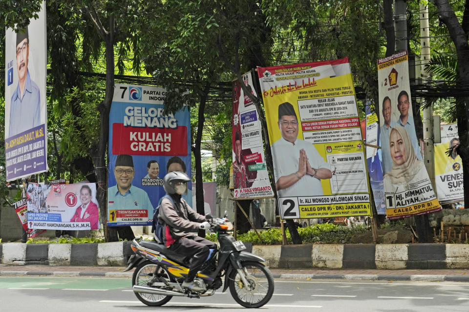 A motorist rides past banners of legislative candidates in Jakarta, Indonesia, on Jan. 24, 2024. The world's third-largest democracy will hold national elections on Feb. 14. (AP Photo/Achmad Ibrahim)