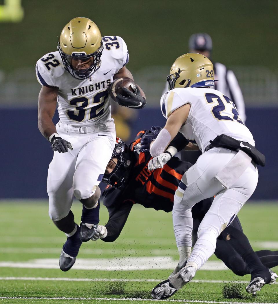 Hoban running back Lamar Sperling, left, hops past Massilon defensive back Zachary Liebler during the second half of an OHSAA Division II state semifinal, Friday, Nov. 25, 2022, in Akron.