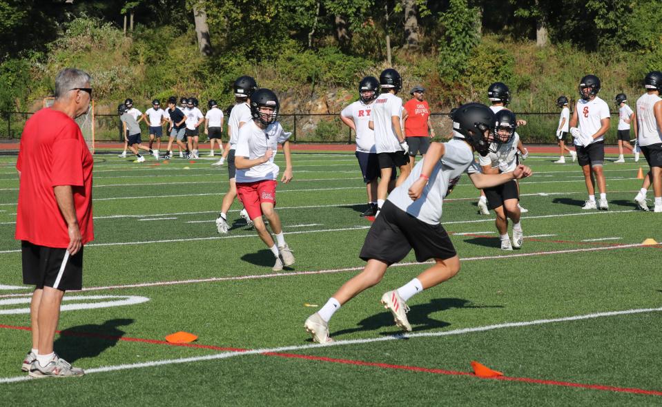 Football players run drills on the first day of Varsity and Junior Varsity football practice at Rye High School, Aug. 20, 2022.