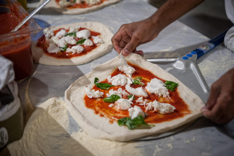 A man preparing pizza.