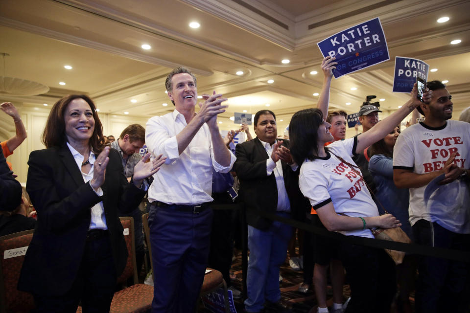 FILE - In this Nov. 3, 2018 file photo, Sen. Kamala Harris, D-Calif., left, and California Democratic gubernatorial candidate Gavin Newsom applaud as they listen to Katie Porter, a congressional candidate for California's 45th District, during a campaign rally in Irvine, Calif. The Southern California county between Los Angeles and San Diego long known as a GOP stronghold now has more registered Democrats than Republicans. Orange County's Registrar of Voters reports Wednesday, Aug. 7, 2019, there are 89 more Democrats than Republicans among its 1.6 million registered voters. (AP Photo/Jae C. Hong, File)