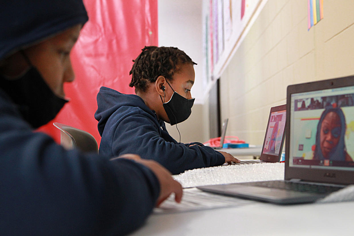 Remote learning has “forced many parents to leave the workforce or work from home while also supporting their children’s learning." Here, 11-year-old twins are seen participating in remote learning in Boston.