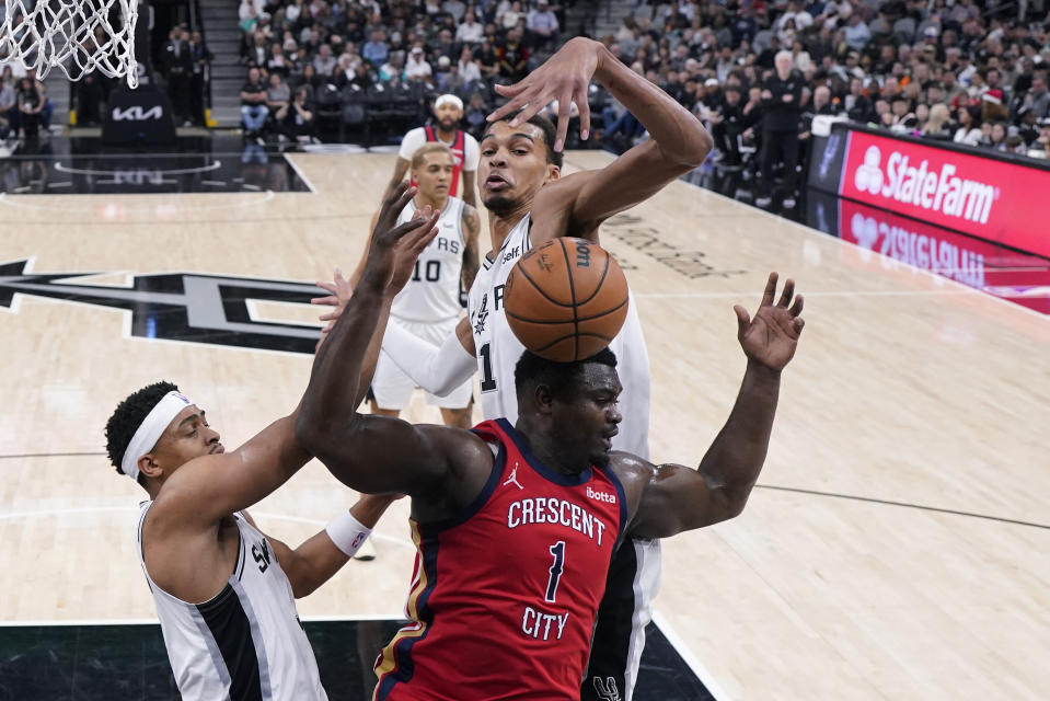 San Antonio Spurs center Victor Wembanyama, top, blocks New Orleans Pelicans forward Zion Williamson, front right, during the second half of an NBA basketball game in San Antonio, Sunday, Dec. 17, 2023. (AP Photo/Eric Gay)