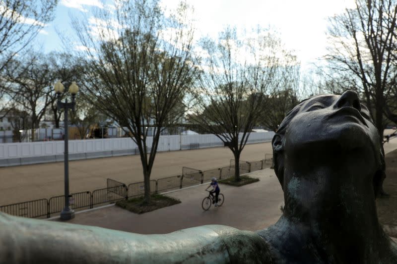 The figure on a monument to the Marquis de Lafayette frames the empty plaza during the coronavirus outbreak, at the White House on Pennsylvania Avenue in Washington