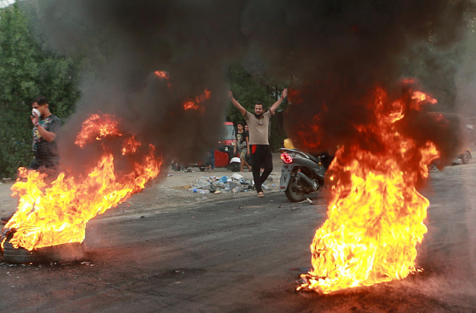 FILE - In this Oct. 6, 2019 file photo, anti-government protesters set fires and close a street during a demonstration in Baghdad, Iraq. A family member of Shujaa al-Khafaji, a popular Iraqi blogger, said authorities have detained him, apparently over his coverage of anti-government protests. The family member, who spoke on condition of anonymity for fear of reprisals, said heavily armed masked gunmen stormed the apartment of al-Khafaji in Baghdad at dawn Thursday, Oct. 17, 2019 and took him away. (AP Photo/Khalid Mohammed, File)