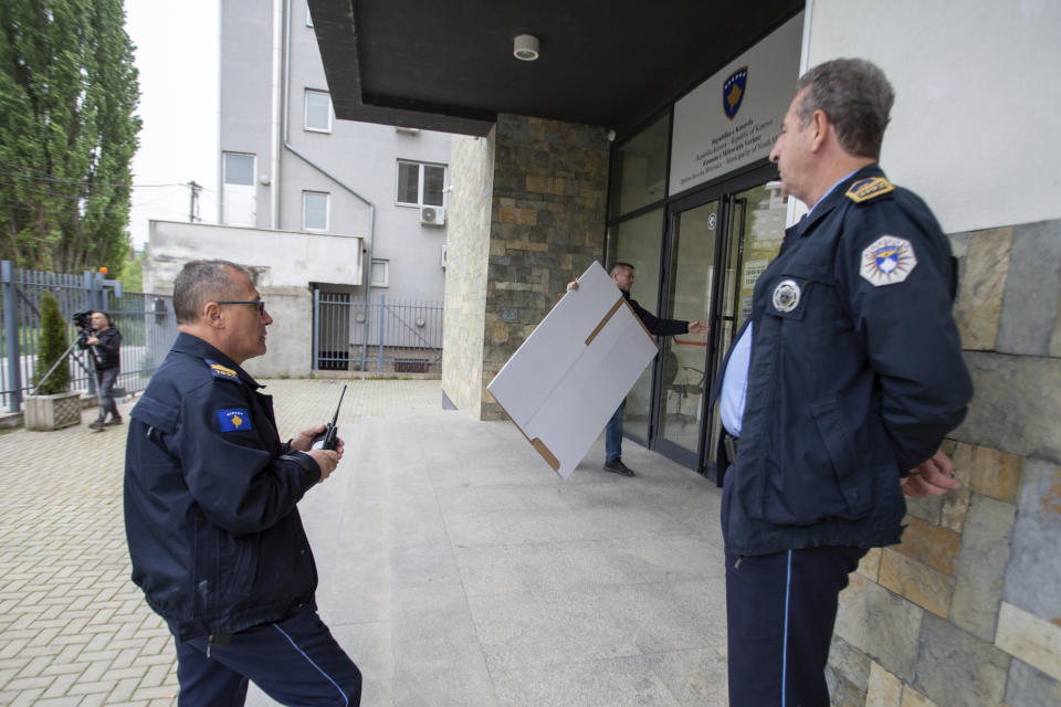 A Kosovo election official carries a voting material at a polling station in the municipality building in North Mitrovica, Kosovo Sunday, April 21, 2024. Residents of four Serb-majority municipalities are casting their votes Sunday in a referendum to decide whether to remove their ethnic Albanian mayors from office following last year’s mayoral elections, overwhelmingly boycotted by the Serb minority. (AP Photo/Visar Kryeziu)