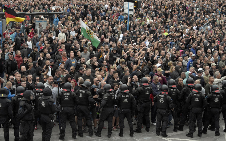 Men shout during a far-right protest in Chemnitz, Germany, Monday, Aug. 27, 2018 after a man has died and two others were injured in an altercation between several people of "various nationalities" in the eastern German city of Chemnitz on Sunday. (AP Photo/Jens Meyer)