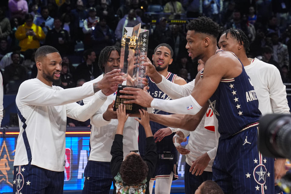 The East team, lead by captain Milwaukee Bucks forward Giannis Antetokounmpo, right, hoists the trophy after defeating the West 211-186 in the NBA All-Star basketball game in Indianapolis, Sunday, Feb. 18, 2024. (AP Photo/Darron Cummings)