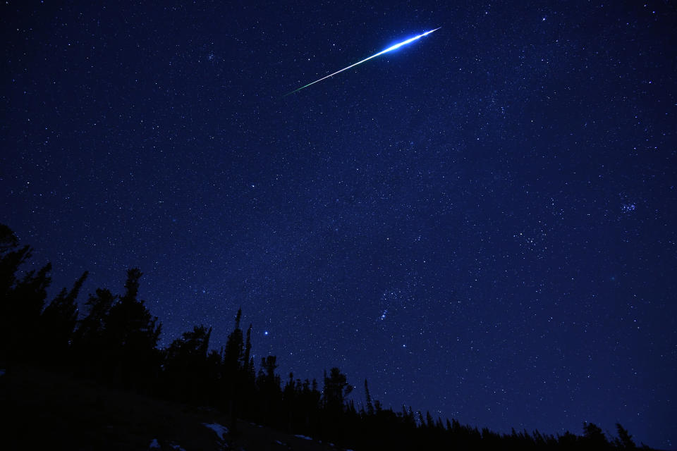 Picture of the Geminids Meteor shower in 2018, showing a meteor flash across the night sky. 