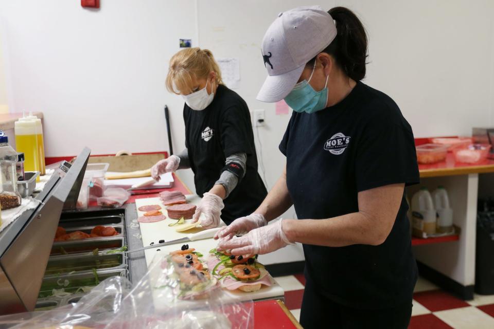 Meredith Stamnas, left, and Patti O’Leary make sandwiches for the lunch rush Tuesday, Feb. 1, 2022, at the Moe’s Italian Sandwiches in Exeter.