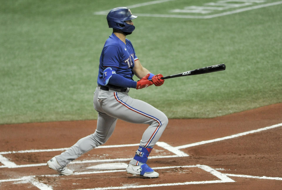 FILE - Texas Rangers' Joey Gallo hits a RBI-single to right field off Tampa Bay Rays' Ryan Yarbrough during the first inning of a baseball game in St. Petersburg, Fla., in this Tuesday, April 13, 2021, file photo. Gallo reached base in each of his first 15 games this season, his only homer being an impressive 450-foot drive to center in the opening series at Kansas City. His other 10 hits were all singles and he had MLB-high 15 walks. (AP Photo/Steve Nesius, File)