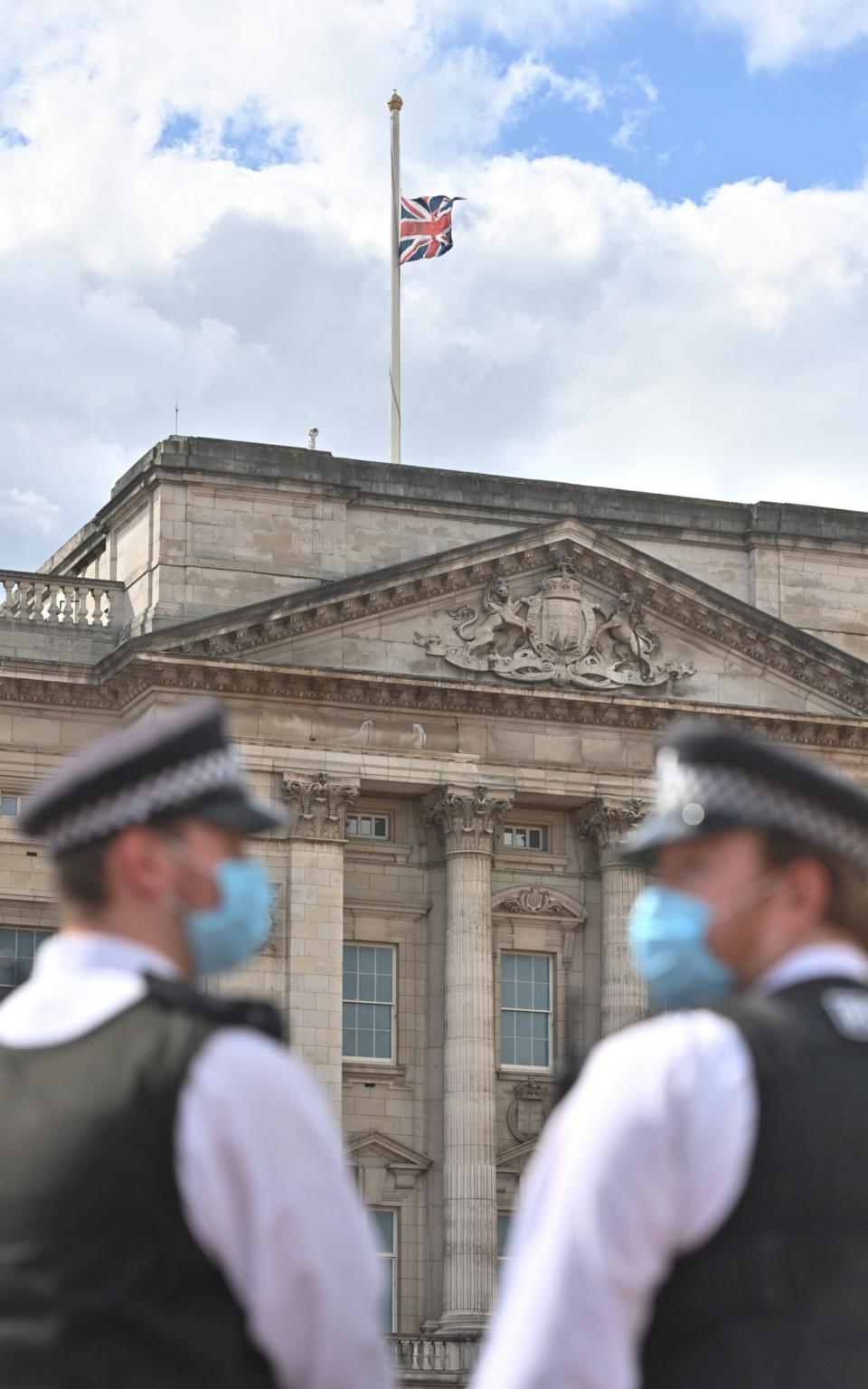 Police look on as the Union flag is flown at half mast on Buckingham Palace  - Geoff Pugh 