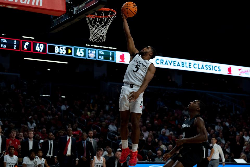 Cincinnati Bearcats guard David DeJulius (5) huts a layup as Cleveland State Vikings forward Cole Middleton (4) looks on in the second half of the men’s NCAA basketball game at Fifth Third Arena in Cincinnati on Thursday, Nov. 10, 2022. Cincinnati Bearcats defeated Cleveland State Vikings 69-58.