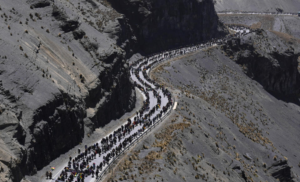 Anti-government coca farmers walk towards the capital, to demand the closure of a parallel market that is promoted by a group related to the government, on the outskirts of La Paz, Bolivia, on Sept. 7, 2022. (AP Photo/Juan Karita)