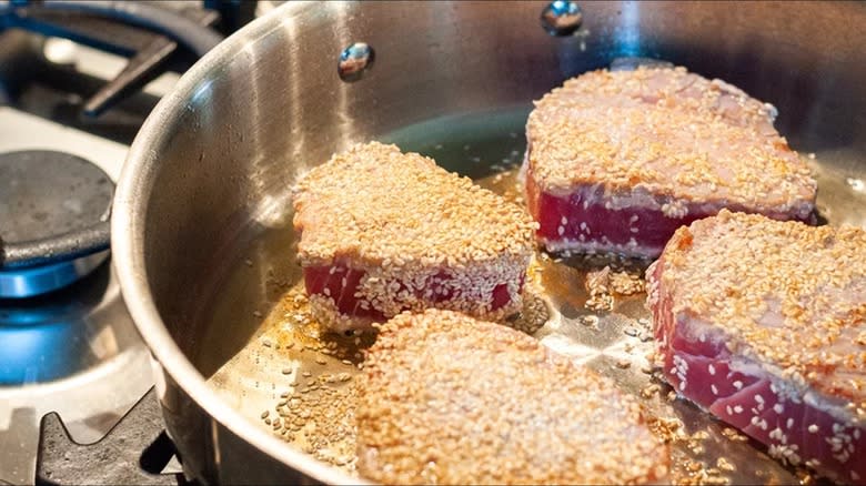 sesame-crusted tuna steaks in a pan