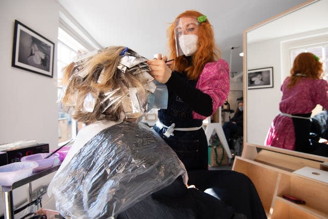 A woman has her hair coloured at the reopening of Flint Hair in Norwich 