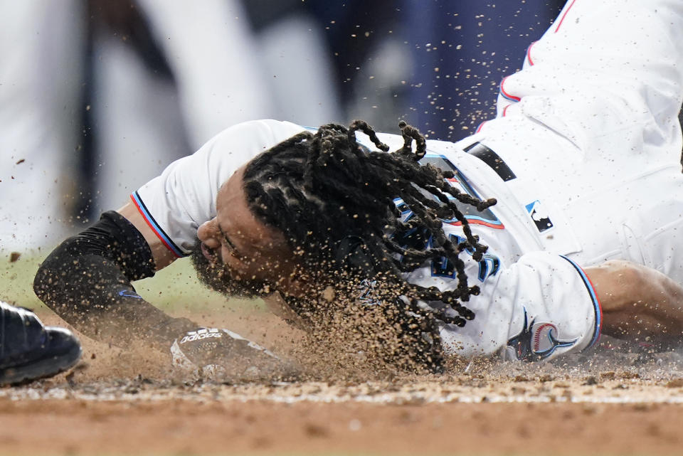 Miami Marlins' Billy Hamilton slides into home to score during the fifth inning of a baseball game against the Pittsburgh Pirates, Thursday, July 14, 2022, in Miami. (AP Photo/Wilfredo Lee)