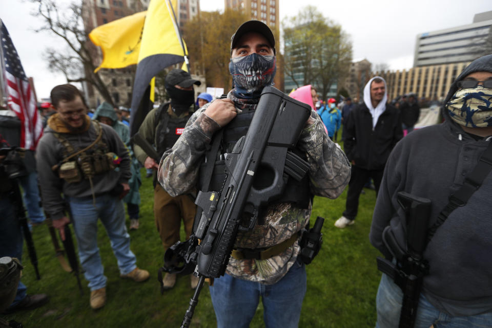 FILE - In this April 30, 2020, file photo, a protester carries his rifle at the State Capitol in Lansing, Mich. Michigan Attorney General Dana Nessel said Friday, May 8, 2020, that a commission overseeing the state Capitol can legally ban guns from the building, contradicting panel leaders' contention that only the Legislature can do so. (AP Photo/Paul Sancya, File)