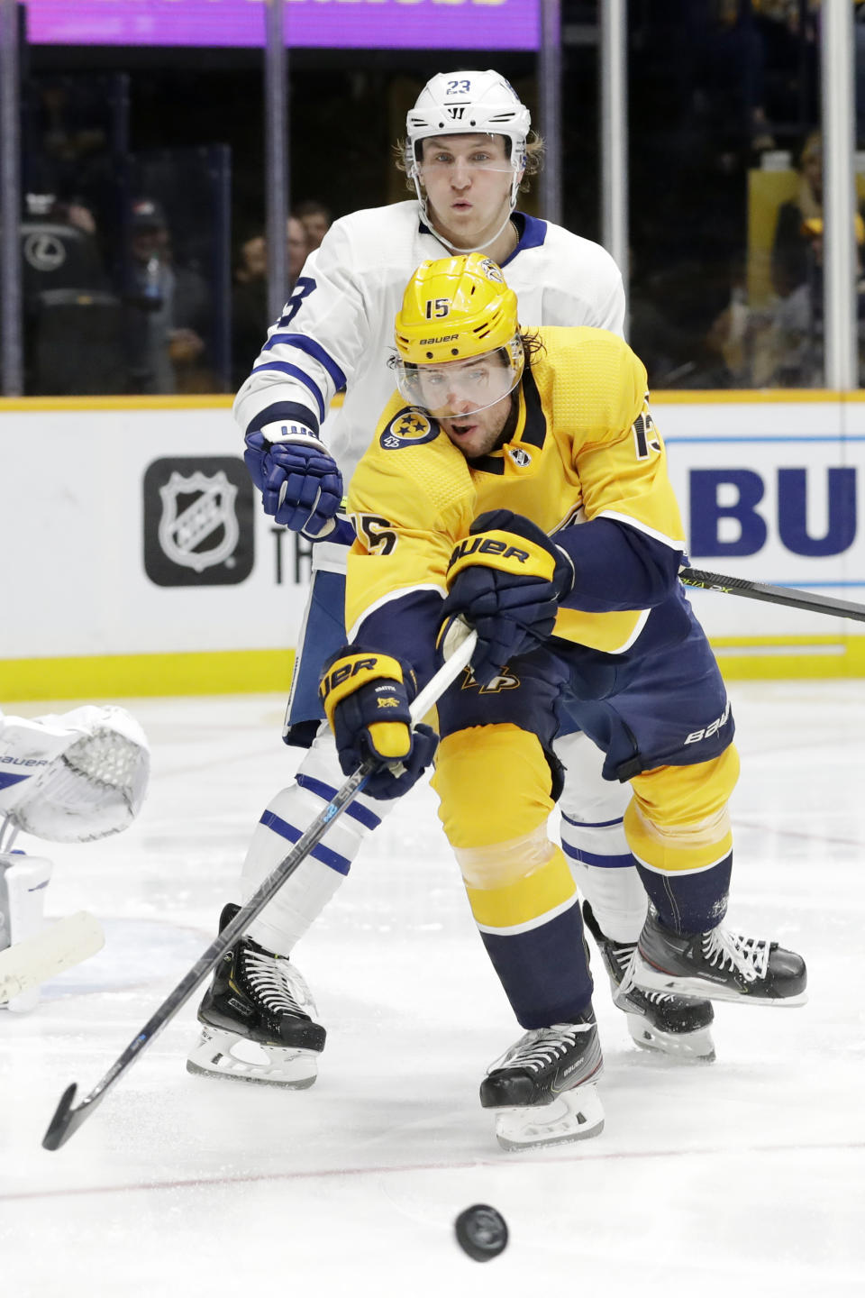 Nashville Predators right wing Craig Smith (15) reaches for the puck in front of Toronto Maple Leafs defenseman Travis Dermott (23) in the second period of an NHL hockey game Monday, Jan. 27, 2020, in Nashville, Tenn. (AP Photo/Mark Humphrey)
