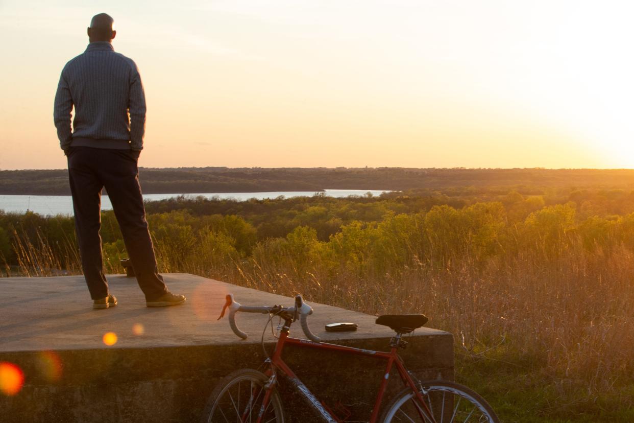 Josh Millstein takes in the last rays of sunlight Friday atop Bunker Hill on the north end of Clinton State Park. Millstein, a resident of Douglas County, biked to the top of the hill from a nearby path that makes up the over 25 miles of hiking and biking trails at Clinton, which last year was the state's second most-visited state park.