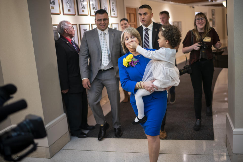 FILE - New Mexico Gov. Michelle Lujan Grisham is silenced by her granddaughter Avery Stewart in this Jan. 21, 2020, file photo while being escorted out following the State of the State address opening the New Mexico legislative session in the house chambers at the state Capitol in Santa Fe, N.M. Michelle Lujan Grisham has not received the attention of many higher profile candidates under consideration to be Joe Biden's running mate. But she has a resume that few of them can match. (AP Photo/Craig Fritz, File)