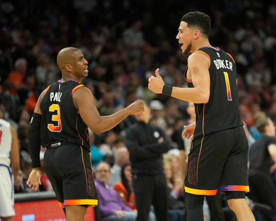 Phoenix Suns guards Chris Paul (3) and Devin Booker (1) talk during Game 1 of the first-round playoff series against the Los Angeles Clippers at Footprint Center in Phoenix on April 16, 2023.