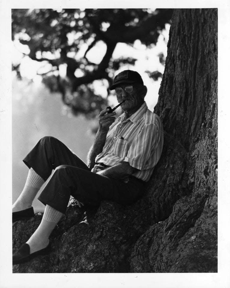 John Sweetman sits underneath the oak tree in his yard.