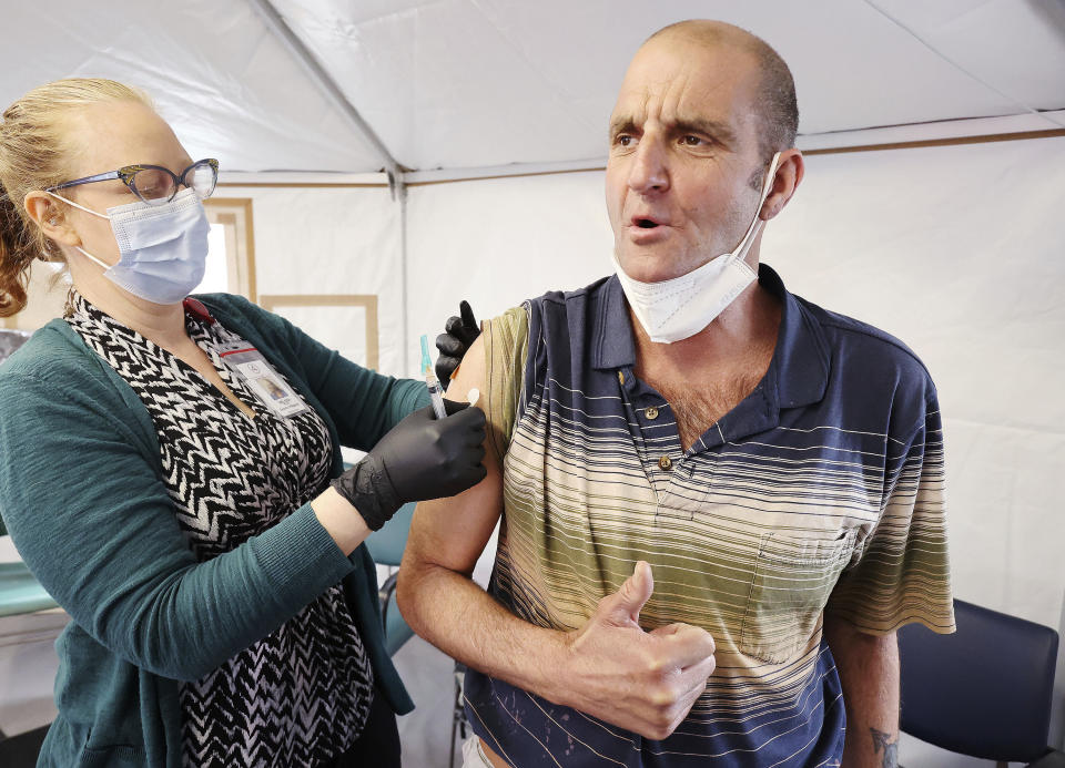 Melissa Mason gives Kenny Collins a COVID-19 vaccination at the Fourth Street Clinic in Salt Lake City on March 23, 2021. Homeless Americans who have been left off priority lists for coronavirus vaccinations — or even bumped aside as states shifted eligibility to older age groups — are finally getting their shots as vaccine supplies increase. (Jeffrey D. Allred/The Deseret News via AP)