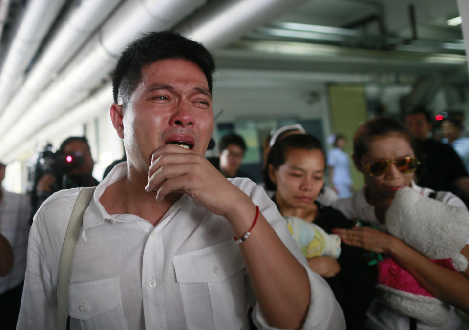 Tayakorn Yos-ubon, left, and Noppawan Chairat, center, the parents of two children killed in Sunday's bomb attack on an anti-government protest site, react as they wait for the bodies at a hospital in Bangkok, Thailand, Monday, Feb. 24, 2014. Two young siblings, 6-year-old girl Patcharakorn and her 4-year-old brother Korawit, along with another woman were killed in an apparent grenade attack against anti-government protesters occupying an upscale shopping area of Thailand's capital on Sunday, the latest violence in a months-long political crisis that is growing bloodier by the day. (AP Photo/Wason Wanichakorn)