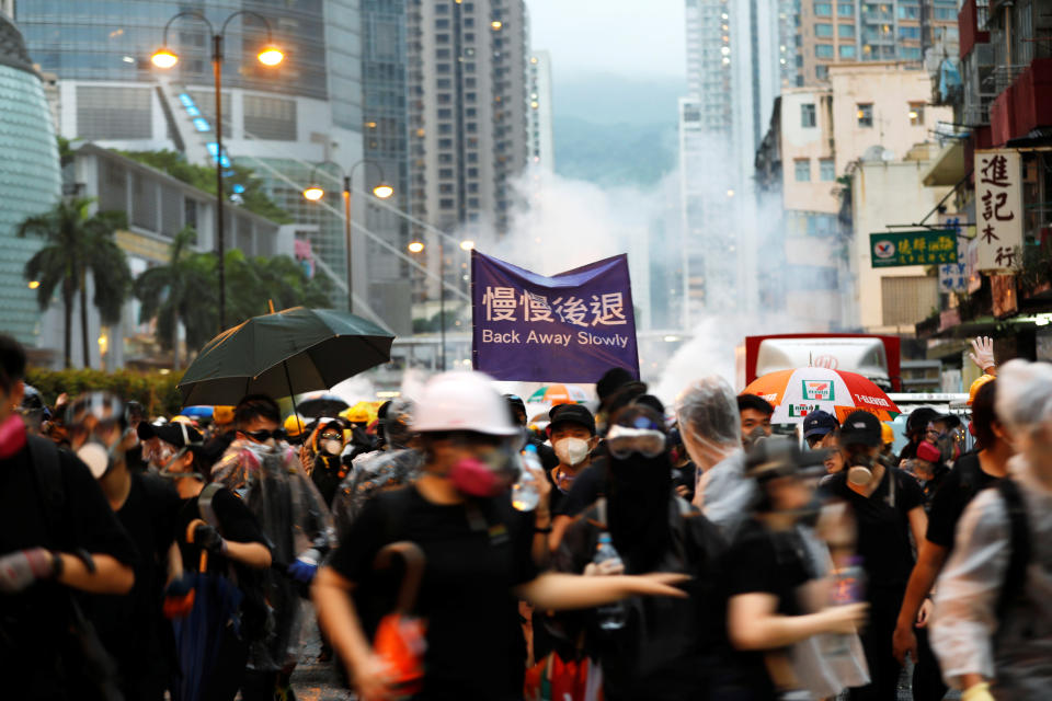 Anti-extradition bill protesters run as riot police fire tear gas during a protest in Hong Kong, China, August 25, 2019. REUTERS/Willy Kurniawan