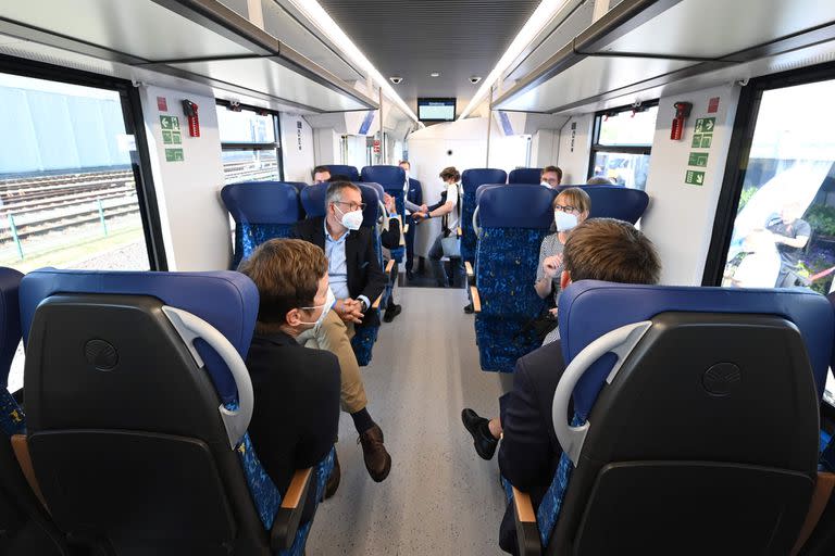 People sit inside a train powered entirely by hydrogen in Bremervoerde, on August 24, 2022. - A fleet of 14 trains provided by French industrial giant Alstom to the German state Lower Saxony replaces diesel locomotives on the 100 kilometres (60 miles) of track connecting the cities of Cuxhaven, Bremerhaven, Bremervoerde and Buxtehude near Hamburg. (Photo by CARMEN JASPERSEN / AFP)