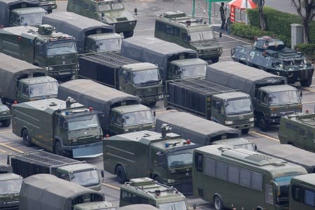 Military vehicles are parked on the grounds of the Shenzhen Bay Sports Center in Shenzhen