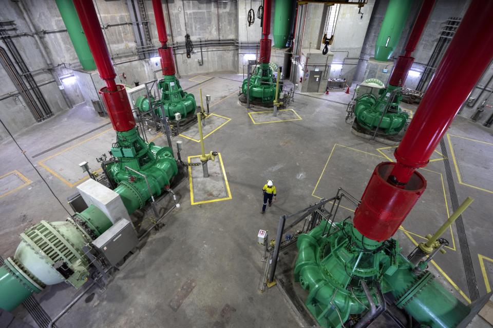 A worker walks through a pumping station at the Changi Water Reclamation Plant in Singapore, Thursday, July 20, 2023. The 50 meter- (164 foot-) deep pumping station receives used water from a sewage tunnel before its treated at the plant into purified NEWater, Singapore's own brand of reclaimed water. (AP Photo/David Goldman)