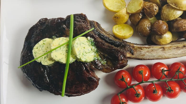 tomahawk steak with vegetables and compound butter