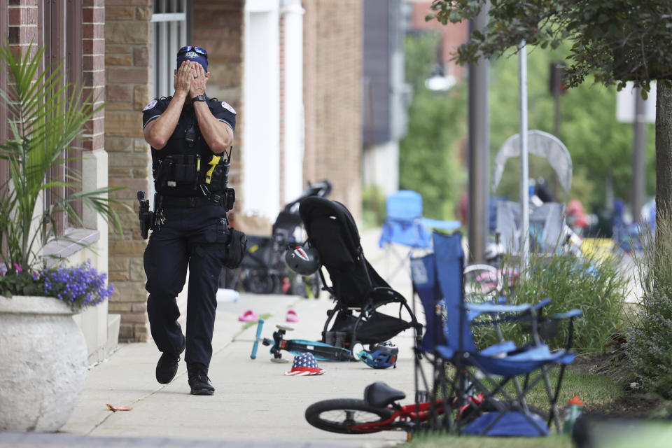 A Lake County police officer walks down Central Ave in Highland Park, Ill. (Brian Cassella / Chicago Tribune via AP)
