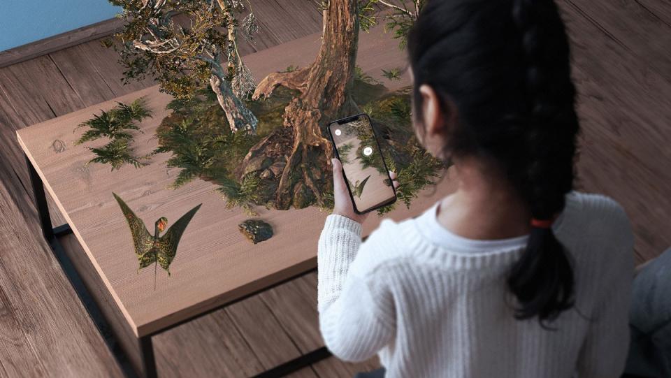 Young girl projecting animal habitat from AR app Museum Alive from her phone