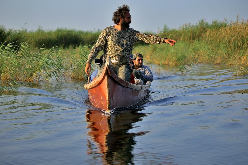 Environmentalist Omar al-Sheikhly leads a team into the marshes in search of endangered animals, in Chibayish, Iraq, Saturday, May, 1, 2021. Deep within Iraq's celebrated marsh lands, conservationists are sounding alarm bells and issuing a stark warning: Without quick action, the UNESCO protected site could all but wither away. (AP Photo/Anmar Khalil)