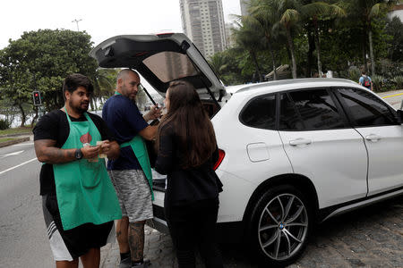 Stefan Weiss (L) and Alexander Costa sell food out of the trunk of a car in Rio de Janeiro, Brazil September 17, 2018. REUTERS/Ricardo Moraes