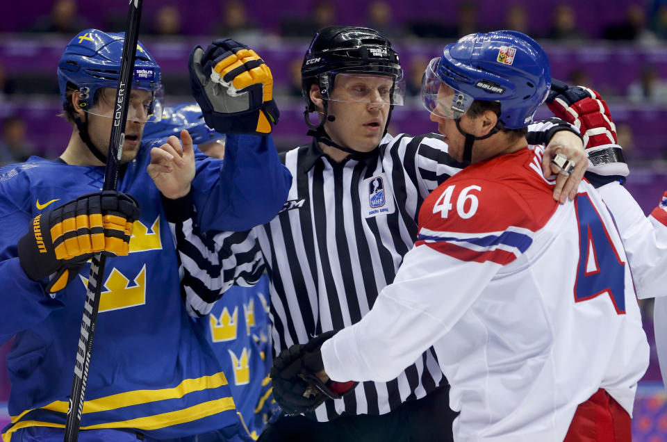 A linesman breaks up a scuffle between Sweden forward Patrik Berglund, left, and Czech Republic forward David Krejci in the first period of a men's ice hockey game at the 2014 Winter Olympics, Wednesday, Feb. 12, 2014, in Sochi, Russia. (AP Photo/Mark Humphrey)