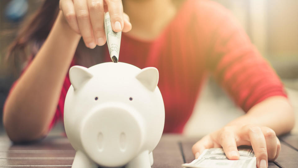 woman putting money in savings bank