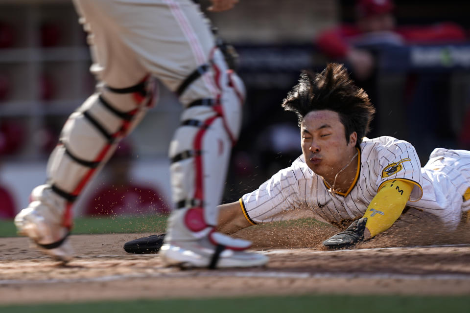 San Diego Padres' Ha-Seong Kim scores past Philadelphia Phillies catcher J.T. Realmuto on a hit by Austin Nola during the fifth inning in Game 2 of the baseball NL Championship Series between the San Diego Padres and the Philadelphia Phillies on Wednesday, Oct. 19, 2022, in San Diego. (AP Photo/Brynn Anderson)