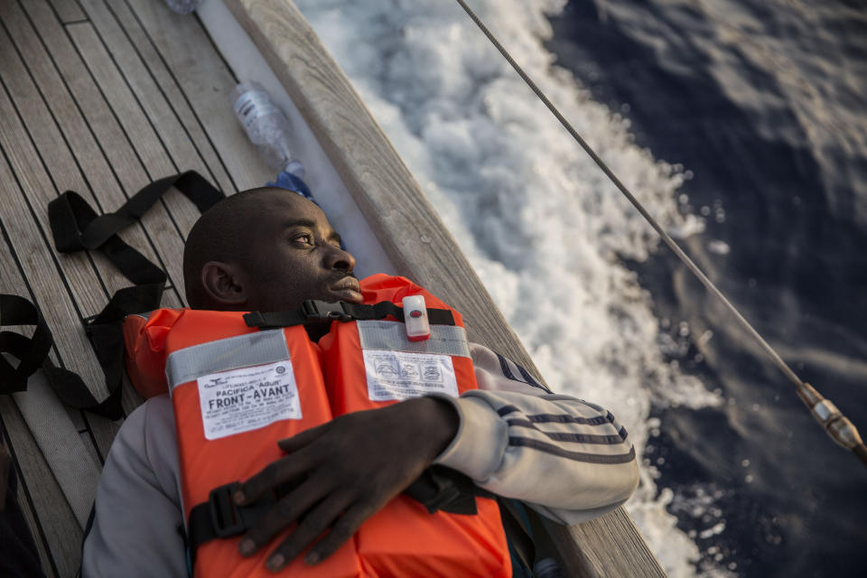 A migrant rests on a Mediterranea Saving Humans NGO boat, as they sail off Italy's southernmost island of Lampedusa, just outside Italian territorial waters, on Thursday, July 4, 2019. An Italian humanitarian group whose boat has been barred from docking in Lampedusa said the health of the 54 migrants it rescued at sea is rapidly deteriorating, prompting fears of another standoff with Italy's populist government. Mediterranea Saving Humans said Friday in a tweet that its sailing boat ALEX was off Italy's southernmost island of Lampedusa, just outside Italian territorial waters, and that it has been banned from entering Italian jurisdiction by ministerial decree. (AP Photo/Olmo Calvo)