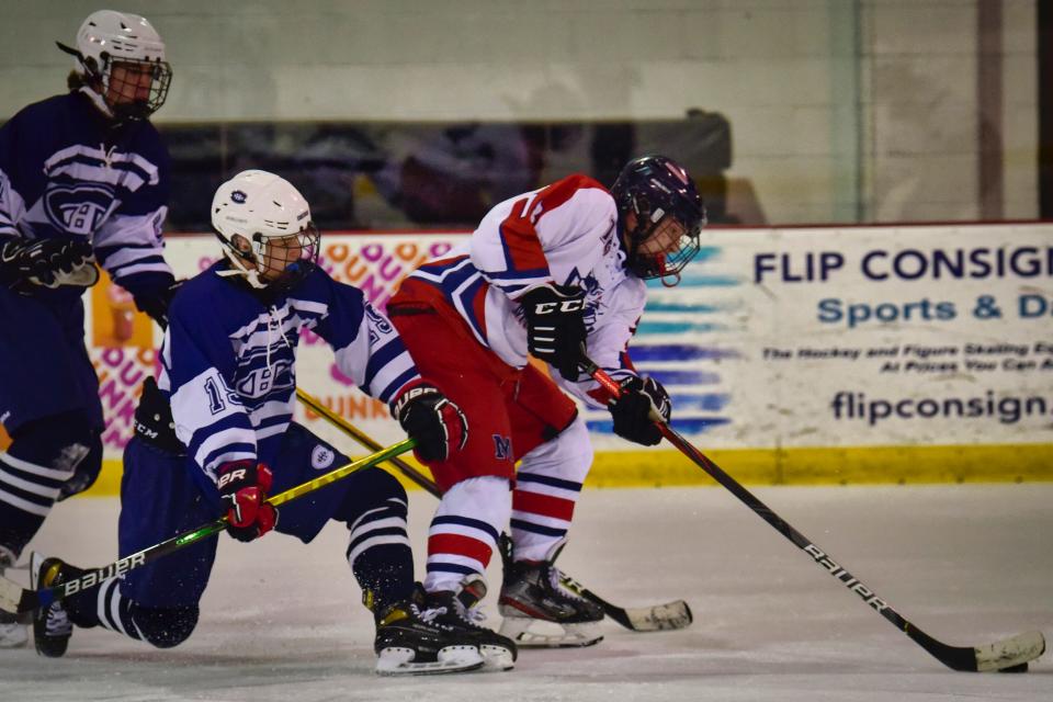 Matthew Nacinovich, #19 of Chatham, pressures Eric Gloie,  #18 of Mendham in the third period during the Essex County Holiday Tournament at Codey Arena in West Orange Monday, Dec.27, 2021.