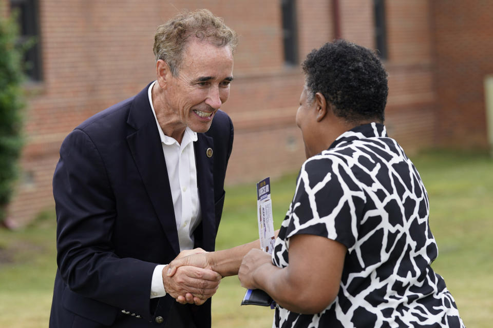 Virginia State Sen. Joe Morrissey, left, greets a voter as he visits a polling precinct Tuesday, June 20, 2023, in Henrico, Va. Morrissey is facing former Delegate Lashrecse Aird in a Democratic primary for a newly redrawn Senate district. (AP Photo/Steve Helber)