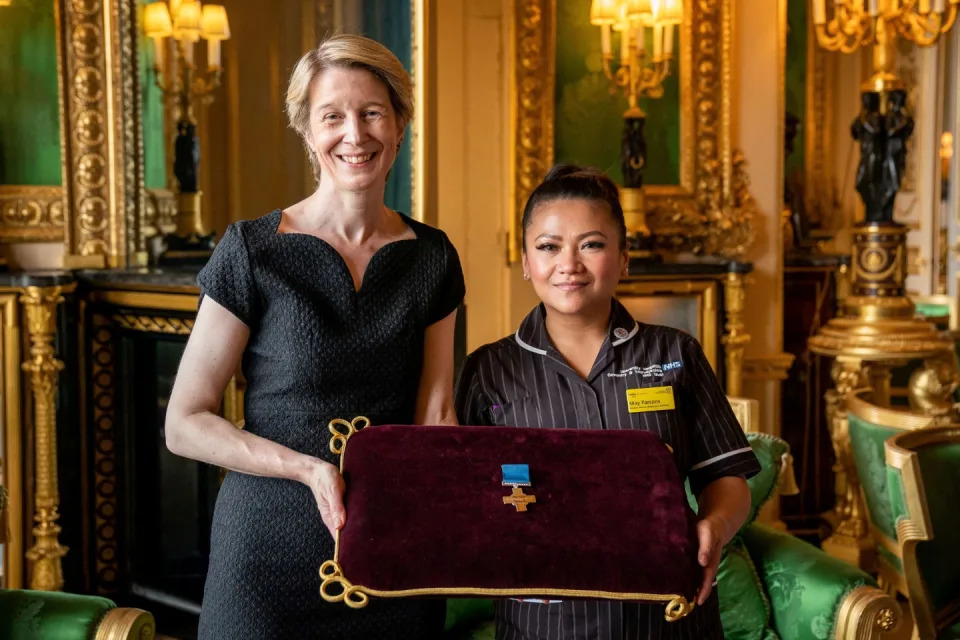 NHS England CEO Amanda Pritchard (L), and Filipina nurse May Parsons, Modern Matron at University Hospital Coventry and Warkwickshire pose with a George Cross medal awarded to NHS England during an Audience at Windsor Castle, west of London on July 12, 2022.
